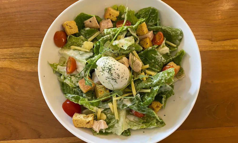Caesar salad with romaine lettuce, croutons, chicken, and a soft-boiled egg at Blue Coast Asian Cuisine, a Asian restaurant in Davenport