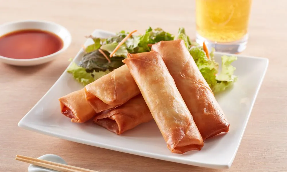 Crispy fried spring rolls with lettuce garnish and dipping sauce on the side at Blue Coast Asian Cuisine, a Asian restaurant in Davenport
