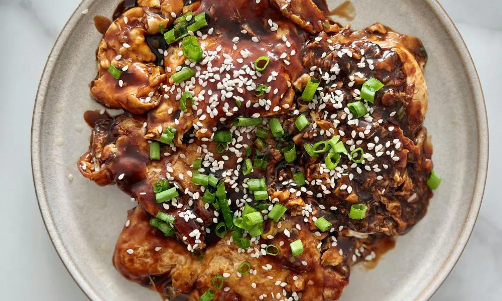 Teriyaki glazed chicken topped with sesame seeds and green onions on a plate at Blue Coast Asian Cuisine, a Asian restaurant in Davenport