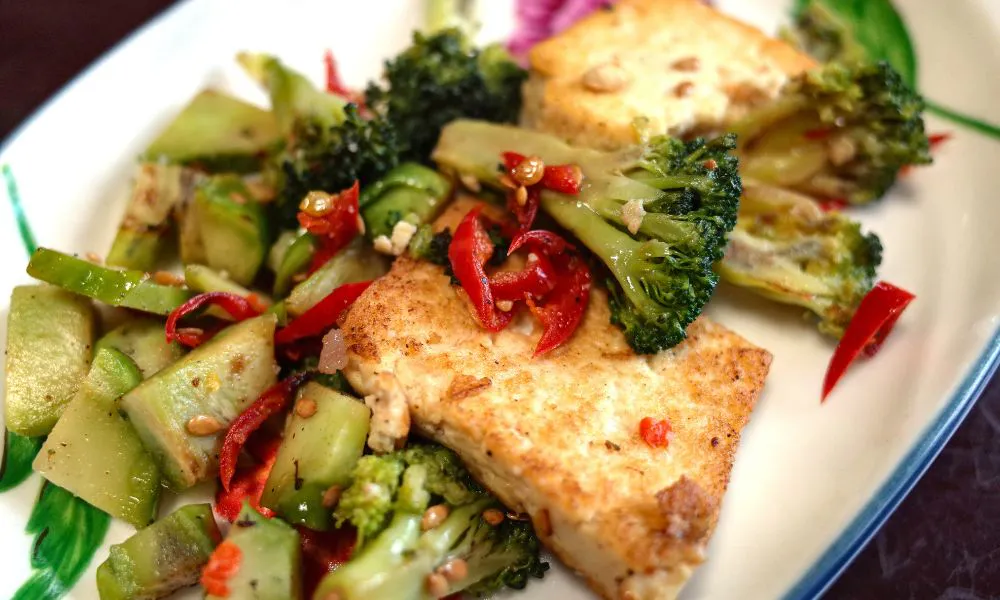 Stir-fried tofu with broccoli, chili peppers, and vegetables on a plate at Blue Coast Asian Cuisine, a Asian restaurant in Davenport Stir-fried tofu with broccoli, chili peppers, and vegetables on a plate at Blue Coast Asian Cuisine, a Asian restaurant in Davenport